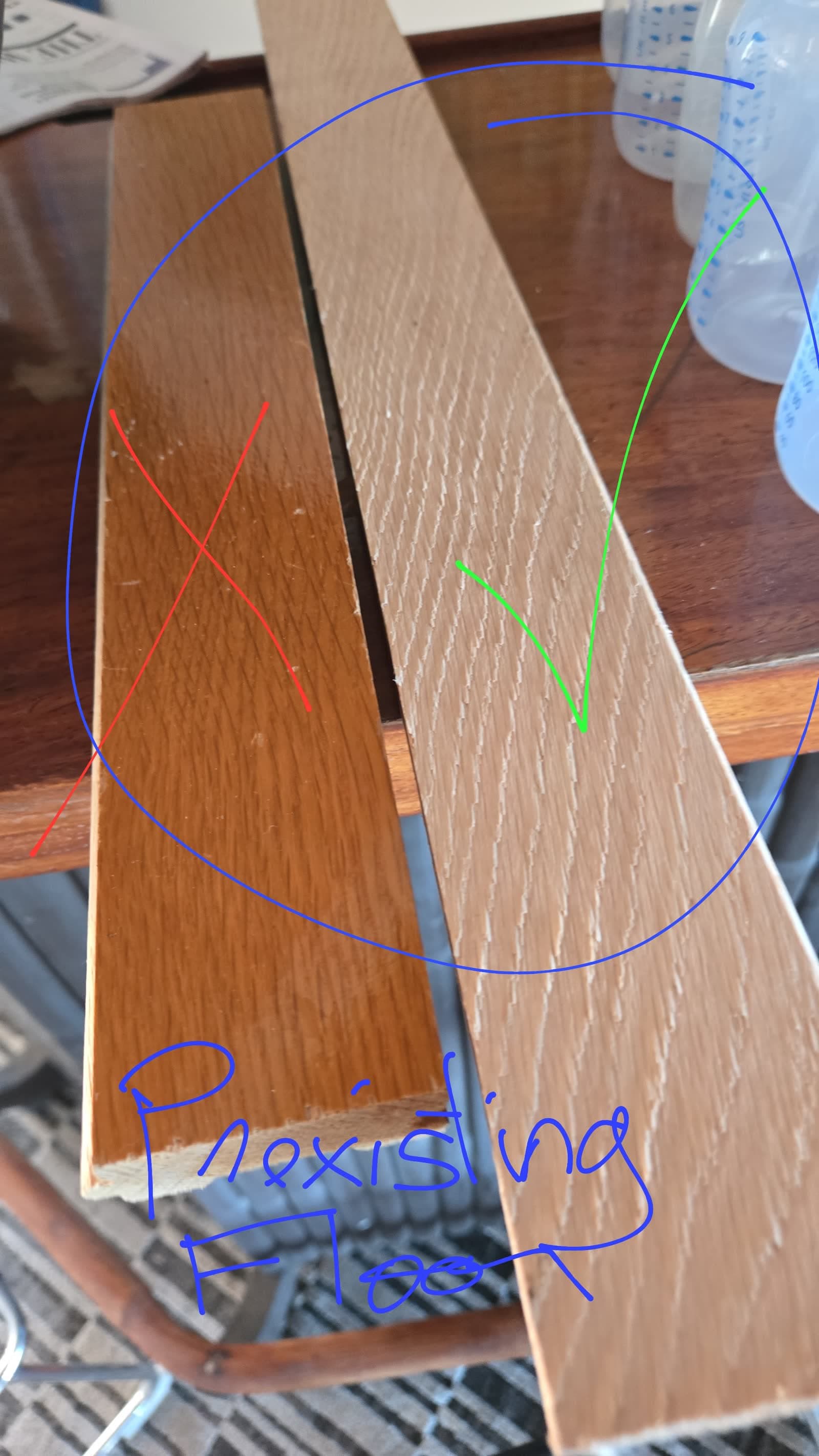 The original white oak floorboard (green check) next to the red oak board the contractor Terminix chose installed (red X), hand-labeled Preexisting Floor